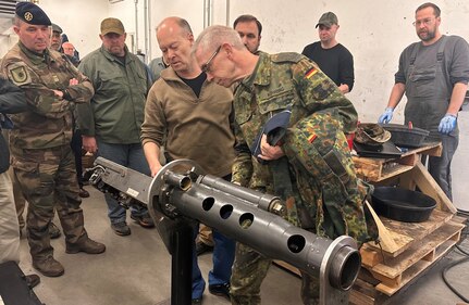 During his visit to the Coleman Army Prepositioned Stocks-2 worksite in Mannheim, Germany, March 16, the Bundeswehr State Command of Baden-Württemberg commander, German air force Col. Thomas Köhring, engages with a German local national armament technician at the site. Köhring was impressed by the detail of work and the technical expertise the German technicians are providing to the 405th Army Field Support Brigade and U.S. Army Europe and Africa. (U.S. Army courtesy photo)