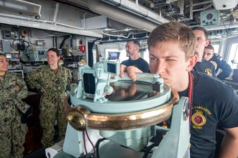 Royal Navy Lt. Oliver Booth scans with a pelorus on the bridge of the Royal Navy frigate HMS Lancaster (F229) in the Gulf of Oman.