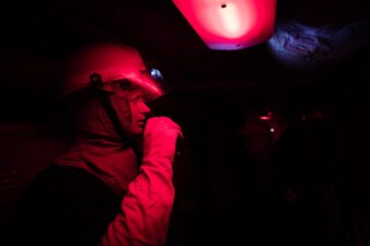 Boatswain's Mate 3rd Class Elijah Butsko communicates the status of simulated flooding during a general quarters drill aboard USS Bunker Hill (CG 52).