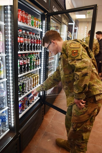 Senior Airman Bailey Miller, Air Force Institute of Technology knowledge management technician, chooses a drink from a cooler at the Army & Air Force Exchange Service micro market in AFIT’s Building 642 on March 15 during the facility’s grand opening. The new facility expands healthy snack and meal possibilities with fresh salads, fruit, beverages and other items. (U.S. Air Force photo by Katie Scott)