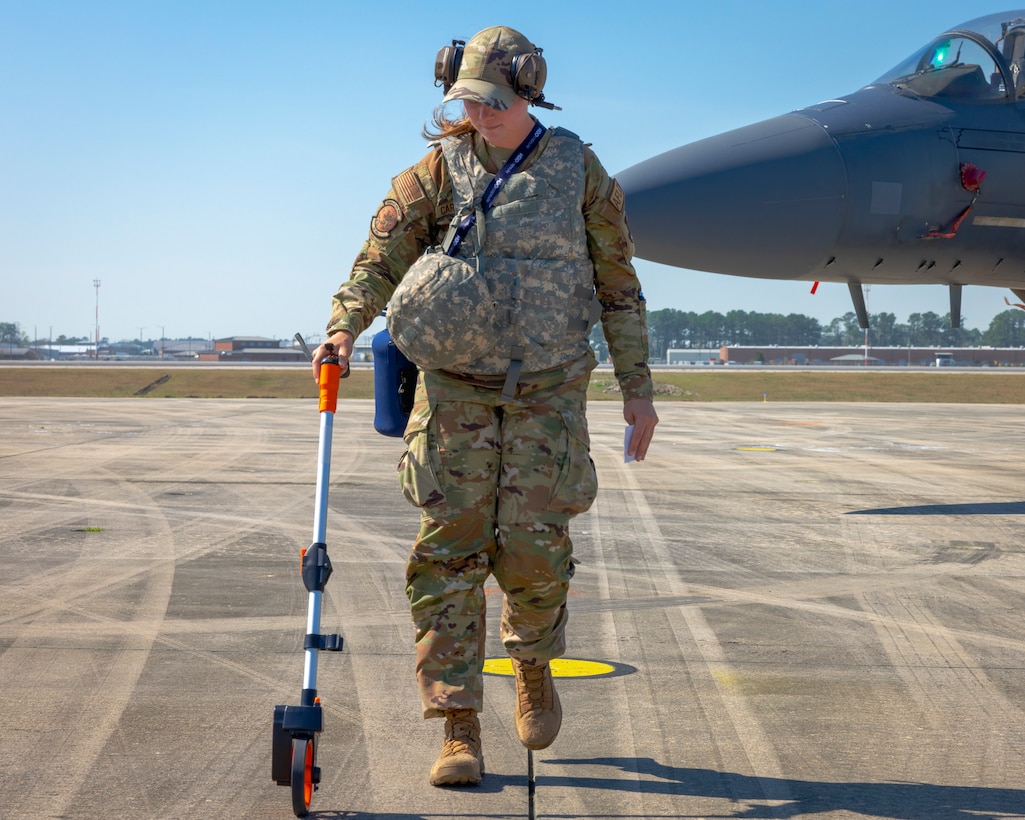 U.S. Air Force Staff Sgt. Taylor Cardarelli, an airfield manager assigned to the 4th Operations Support Squardon, 4th Operations Group, 4th Figher Wing, measures distance to maintain proper spacing for landing F-15E Strike Eagles at Marine Corps Air Station Cherry Point, North Carolina, March 7, 2023. MCAS Cherry Point's customer service, facilities for training, and restricted airspace and ranges at Bombing Targets 9 and 11, and its proximity to Air Force training sites facilitated readiness training for the 4th Fighter Wing and strengthened relationships between its mission partners. (U.S. Marine Corps photo by Cpl. Noah Braswell)