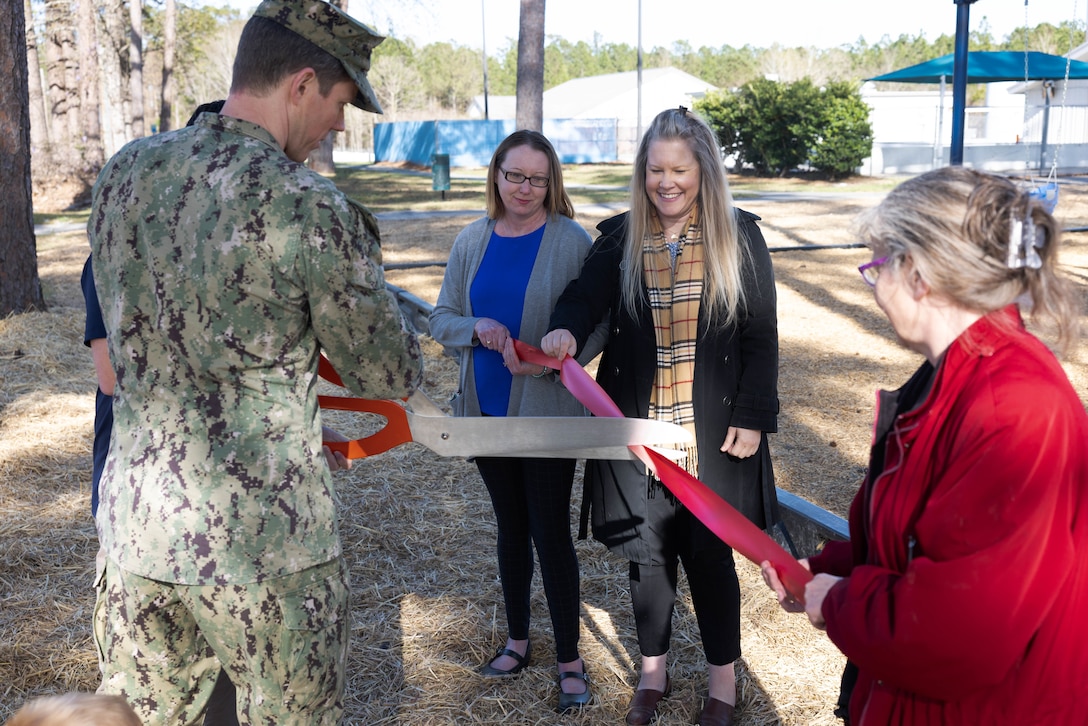 U.S. Navy Cmdr. Brian Schonefeld, Facilities director for Marine Corps Air Station (MCAS) Cherry Point, cuts the ribbon to officially open a new swing set in the Nugent Cove community, MCAS Cherry Point, North Carolina, March 9, 2023. The swing set will provide closer and more suitable recreation areas for children and families within the community, making safer and easier routes to access nearby facilities in their community.  (U.S. Marine Corps photo by Lance Cpl. Tristen Reed)