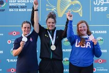 Women in their country's uniform with medals in front of ISSF World Cup backdrop.