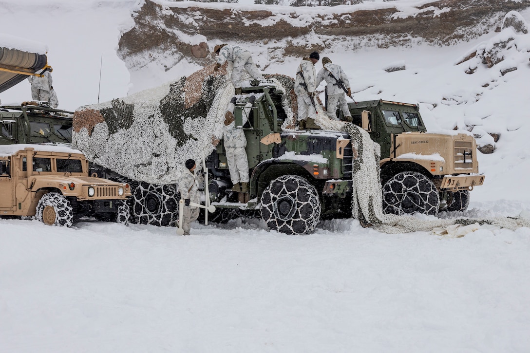 U.S. Marines with Combat Logistics Battalion 2, Combat Logistics Regiment 2, 2nd Marine Logistics Group, set up camouflage netting to conceal vehicles during Exercise Joint Viking near Bardufoss, Norway, March 9, 2023. Marines are deployed to Norway as part of Marine Rotational Forces Europe 23.1 which focuses on regional engagements throughout Europe by conducting various exercises, arctic cold-weather and mountain warfare training, and military-to-military engagements, which enhance overall interoperability of the U.S. Marine Corps with allies and partners. (U.S. Marine Corps photo by Sgt. Christian M. Garcia)