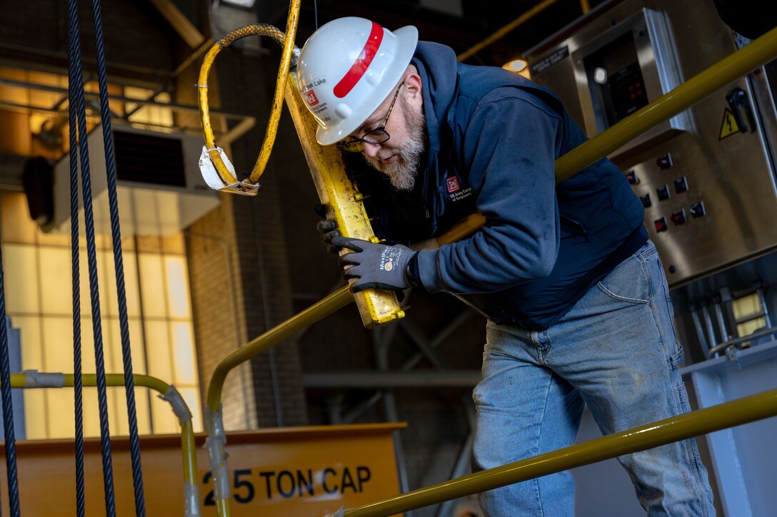 Brent Kelly, a maintenance mechanic, stands above the old hoist and assists the team in placing a block before removing the old gate hoist from Crooked Creek Dam’s control tower in Ford City, Pennsylvania, Feb. 14, 2023. BCI Construction installed four new hoists – each weighing 38,000 pounds apiece and control the dam’s gates – at Crooked Creek Lake to modernize the facility’s machinery and improve usage. The new hoists make the machinery safer and more efficient to use, with digital displays that are more accurate and easier to read. The original hoists were in operation since the dam was built in 1938. (U.S. Army Corps of Engineers photo by Andrew Byrne)