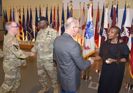 Col. Tony Nesbitt, center left, outgoing commander of U.S. Army Medical Logistics Command, shakes hands with Brig. Gen. Anthony McQueen, commanding general of U.S. Army Medical Research and Development Command and Fort Detrick, Maryland, following a relinquishment of command ceremony March 10 at Fort Detrick. Also pictured at right is Nesbitt’s sister, Donna Benjamin.