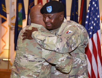 Col. Tony Nesbitt, outgoing commander of U.S. Army Medical Logistics Command, embraces Col. Clayton Carr, AMLC’s assistant chief of staff for operations, following a relinquishment of command ceremony March 10 at Fort Detrick, Maryland. Nesbitt, who is retiring, passed the baton to Col. Gary Cooper, who assumed interim command for the organization.