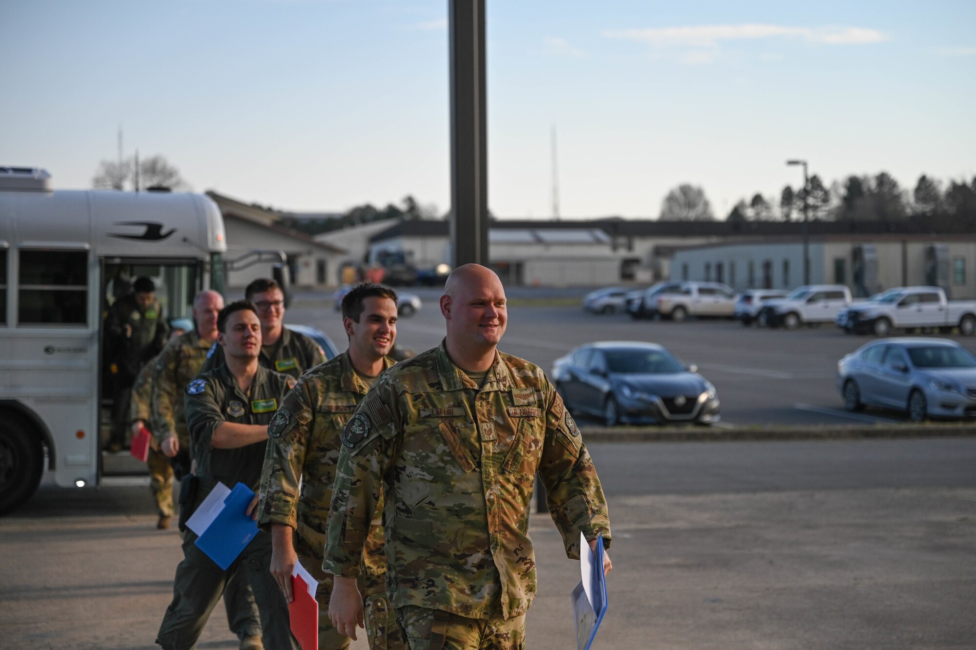 Men in uniform walk into a building.