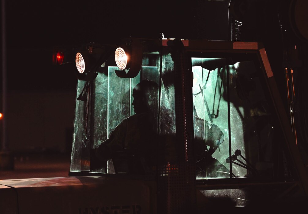A man in uniform drives a forklift.