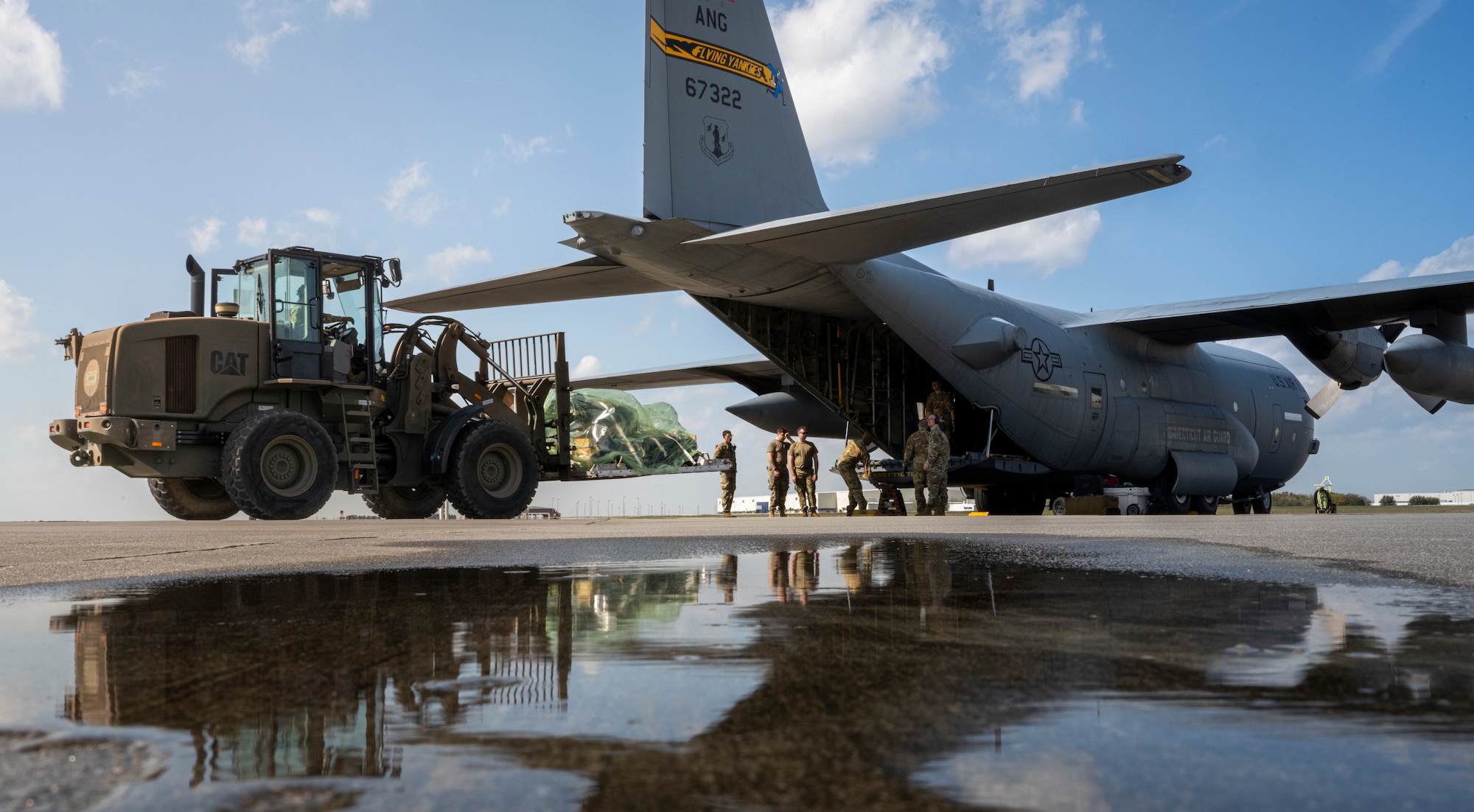 Airmen assaigned to the 621st Contingency Response Wing  load cargo onto a Lockheed C-130 Hercules aircraft assigned to the 103rd Airlift Wing at Bradley Air National Guard Base, Connecticut for AGILE FLAG 23-1 at Savannah Air National Guard Base, Georgia, Feb. 27, 2023.
