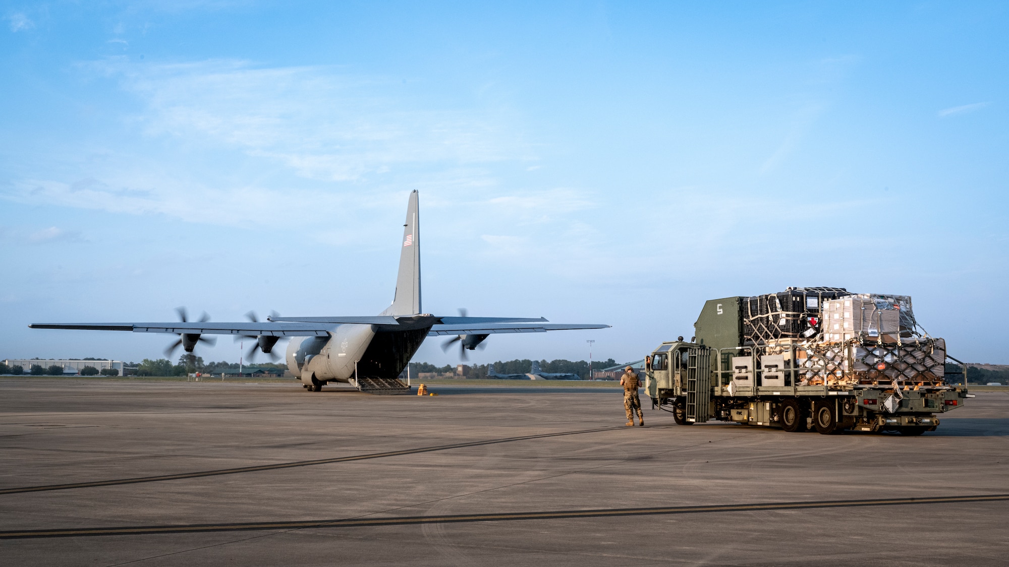 Senior Airman Shayne Paulk, left, a 921st Contingency Response Squadron aerial port mobility team member, waits to load a Lockheed C-130 Hercules aircraft during AGILE FLAG 23-1 at Savannah Air National Guard Base, Georgia, March 3, 2023.