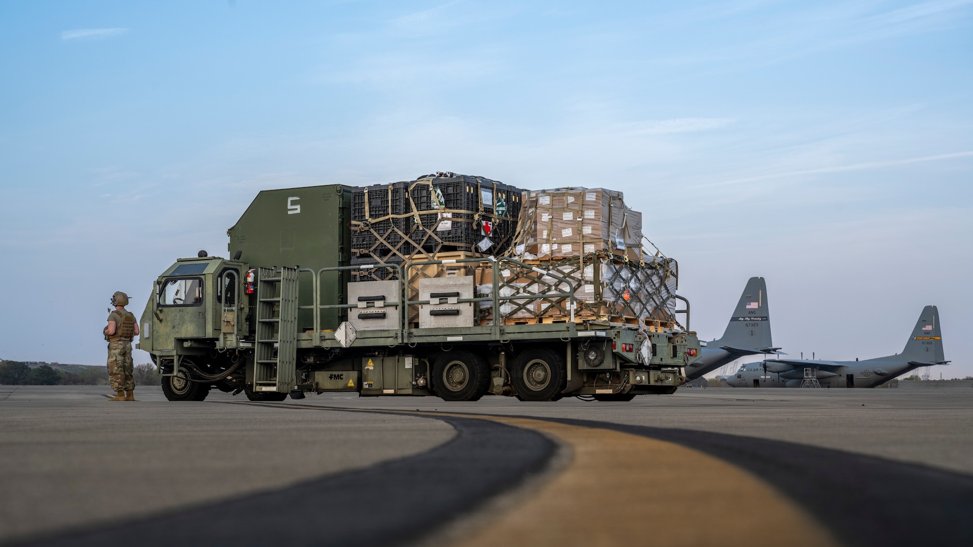 Senior Airman Shayne Paulk, left, a 921st Contingency Response Squadron aerial port mobility team member, waits to load a Lockheed C-130 Hercules aircraft during AGILE FLAG 23-1 at Savannah Air National Guard Base, Georgia, March 3, 2023