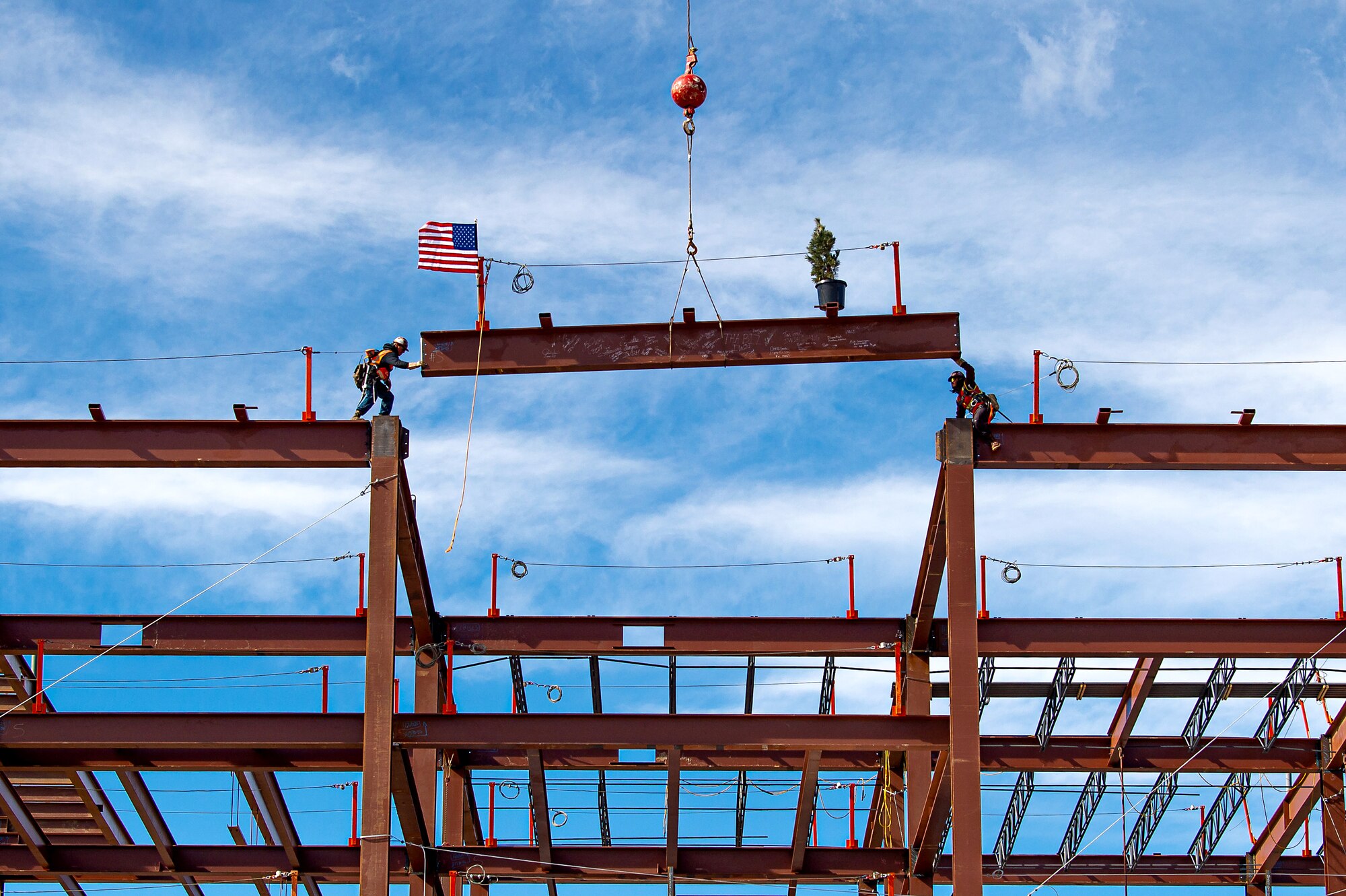 Two construction workers place a horizontal steel beam in position during a topping off ceremony at the Air Force Academy, Colorado on February 14th 2023.