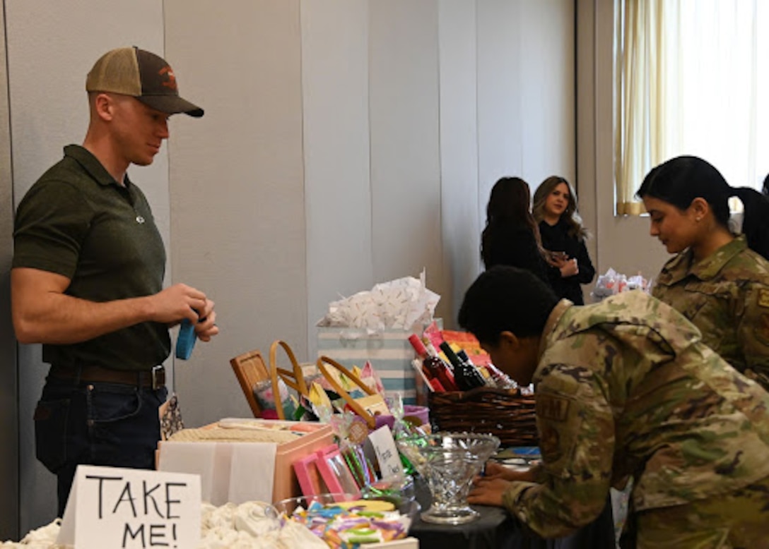Attendees look at prizes displayed on a table at the Women’s History Month event at Joint Base Andrews, Md., March 17, 2023. People had the chance to win prizes for part of a raffle. (U.S. Air Force photo by Airman 1st Class Austin Pate)