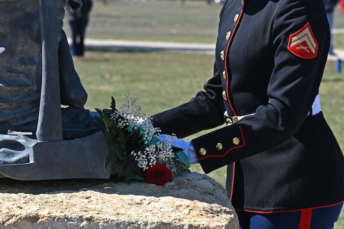 A member of the joint service color guard places a bouquet of flowers upon the fallen firefighter memorial statue during the annual Department of Defense Fallen Firefighter Memorial Service, Goodfellow Air Force Base, Texas, March 17, 2023. The memorial symbolizes the heroism and sacrifice of DOD firefighters that gave their lives in the line of duty. (U.S. Air Force photo by Senior Airman Ashley Thrash)