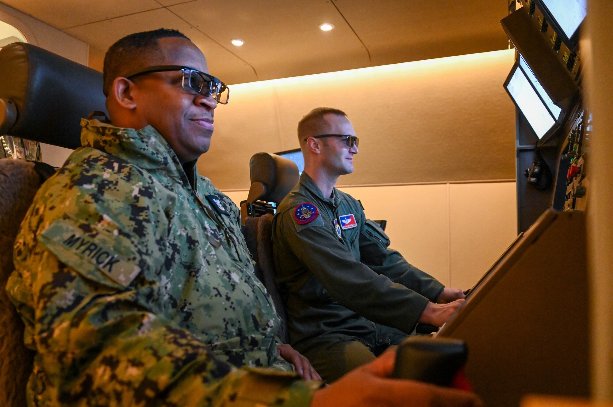 Fleet Master Chief Donald O. Myrick (left), U.S. Transportation Command senior enlisted leader, operates a KC-46 Pegasus boom operator simulator with Master Sgt. Jonathan Lauterbach, 97th Training Squadron boom operator instructor, at Altus Air Force Base, Oklahoma, March 15, 2023. The KC-46 simulator allows pilots and boom operators to practice their craft and receive qualifications before real-time flying. (U.S. Air Force photo by Senior Airman Kayla Christenson)