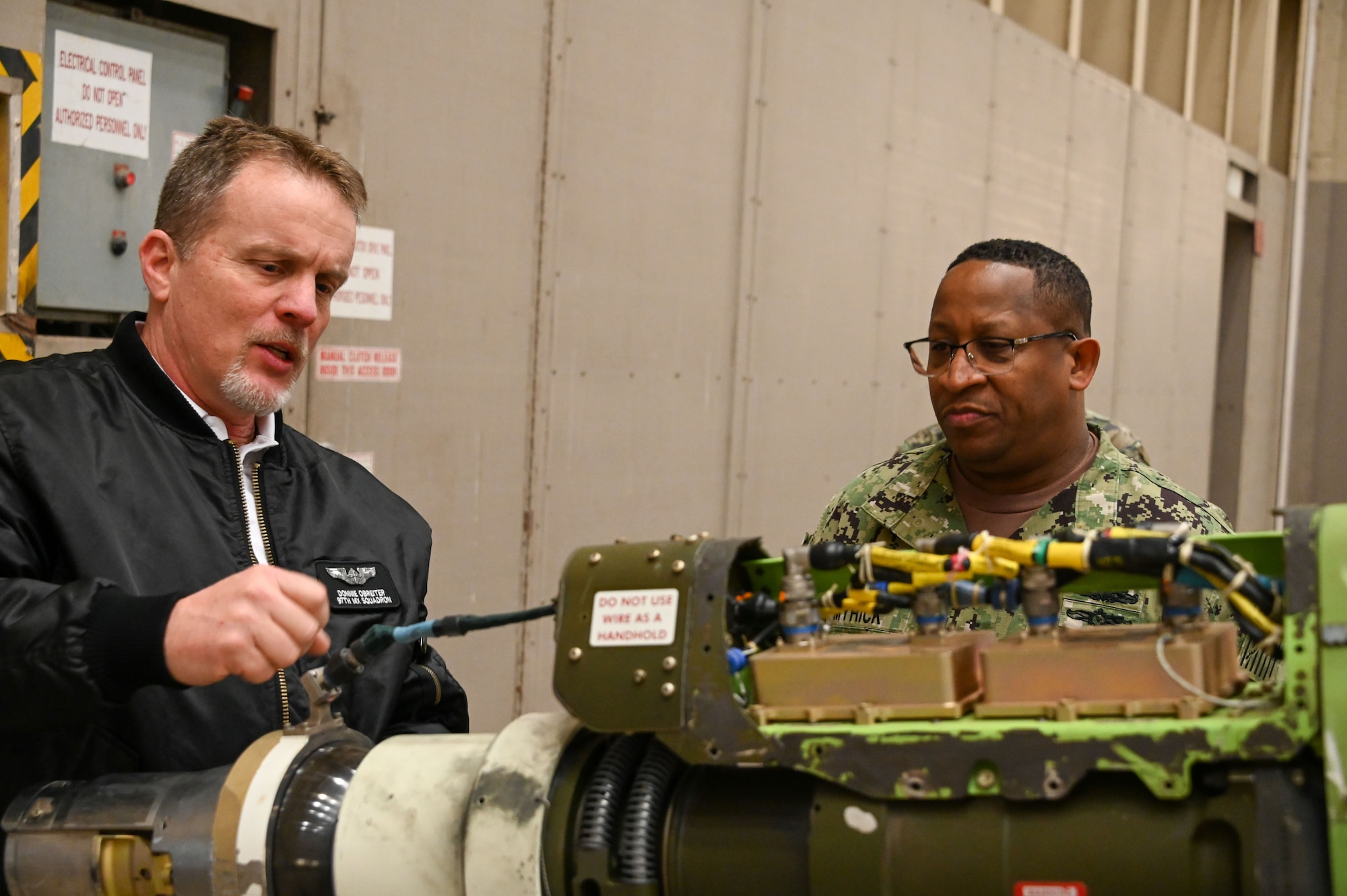 Donnie Obreiter, 97th Maintenance Squadron flight chief, talks about a piece of equipment on the boom of a KC-46 Pegasus to U.S. Navy Fleet Master Chief Donald O. Myrick, U.S. Transportation Command senior enlisted leader, at Altus Air Force Base, Oklahoma, March 13, 2023. The KC-46 is equipped with a refueling boom driven by a fly-by-wire control system and is capable of fuel offload rates required for large aircraft. (U.S. Air Force photo by Senior Airman Kayla Christenson)