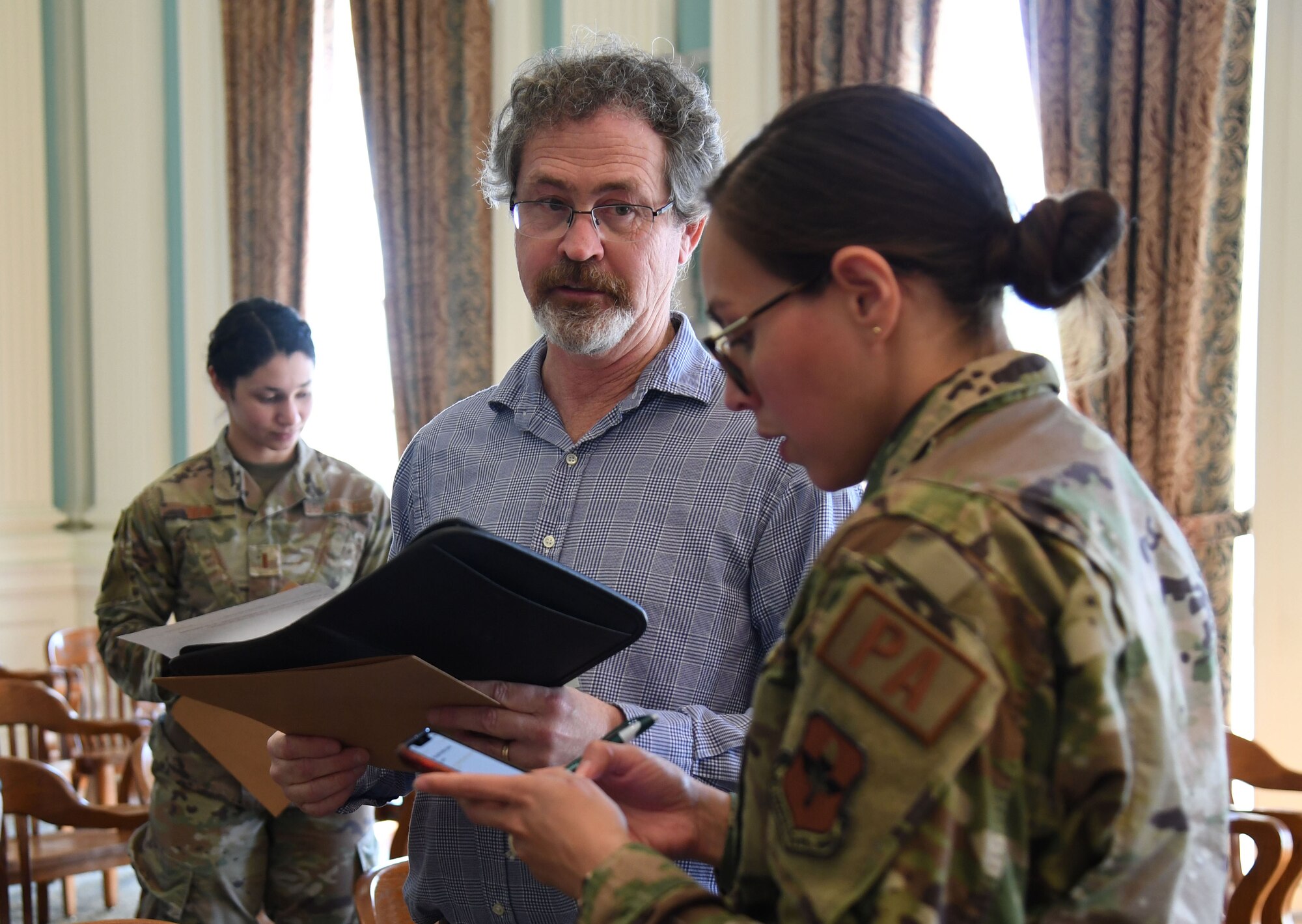 U.S. Air Force Maj. Jennifer Bosco, 81st Training Wing public affairs officer; Joel Van Nice, 81st TRW public affairs base visual information manager, and 2nd Lt. Kristina Dean, 81st TRW public affairs officer, participate in a mock press conference inside Biloxi City Hall during the aircraft mishap exercise at Keesler Air Force Base, Mississippi, March 16, 2023.