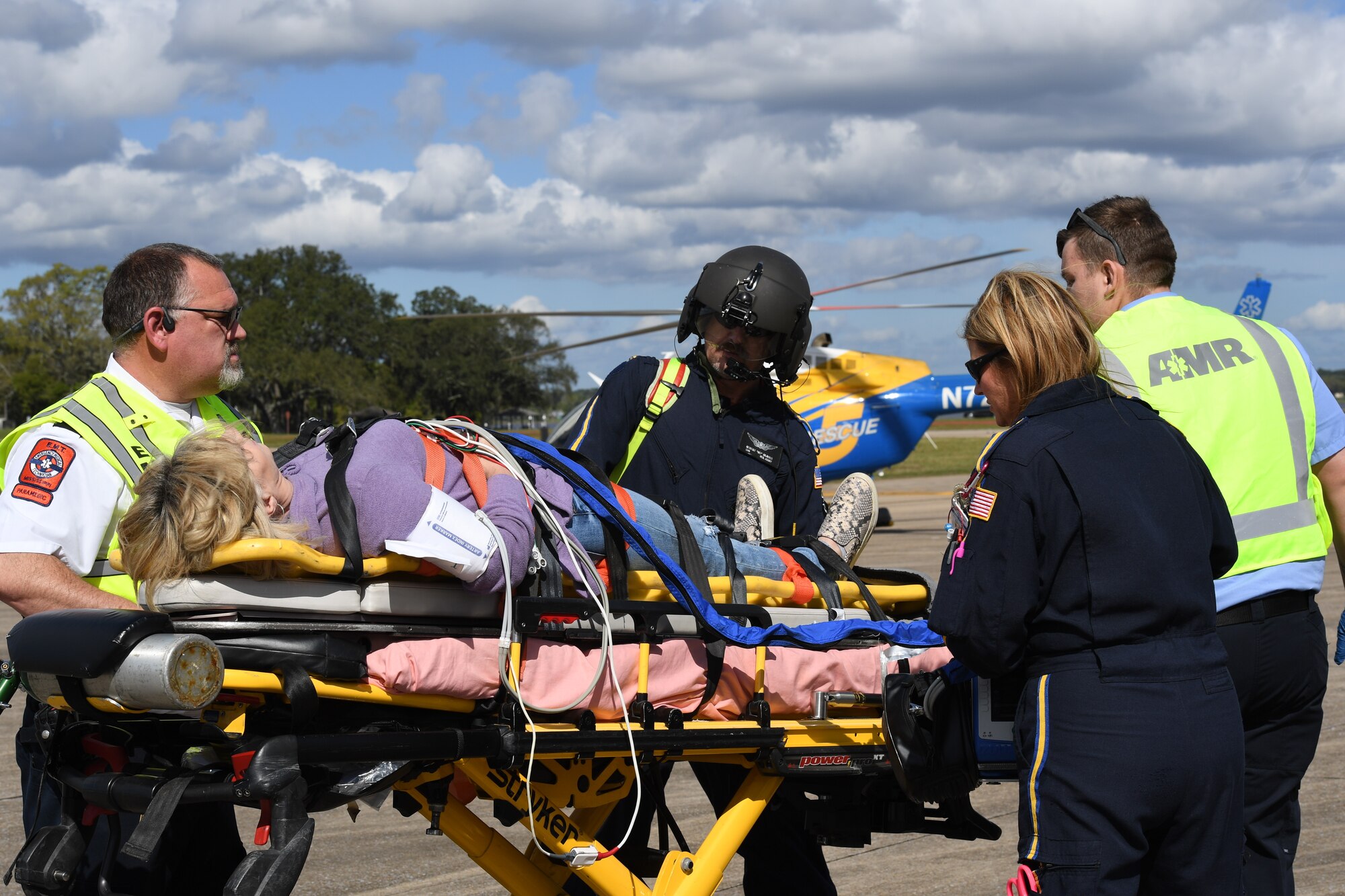 Members of the American Medical Response Team and the Rescue 5 Flight Care Team prepare to transport a simulated patient onto a rescue helicopter during the aircraft mishap exercise at Keesler Air Force Base, Mississippi, March 16, 2023.