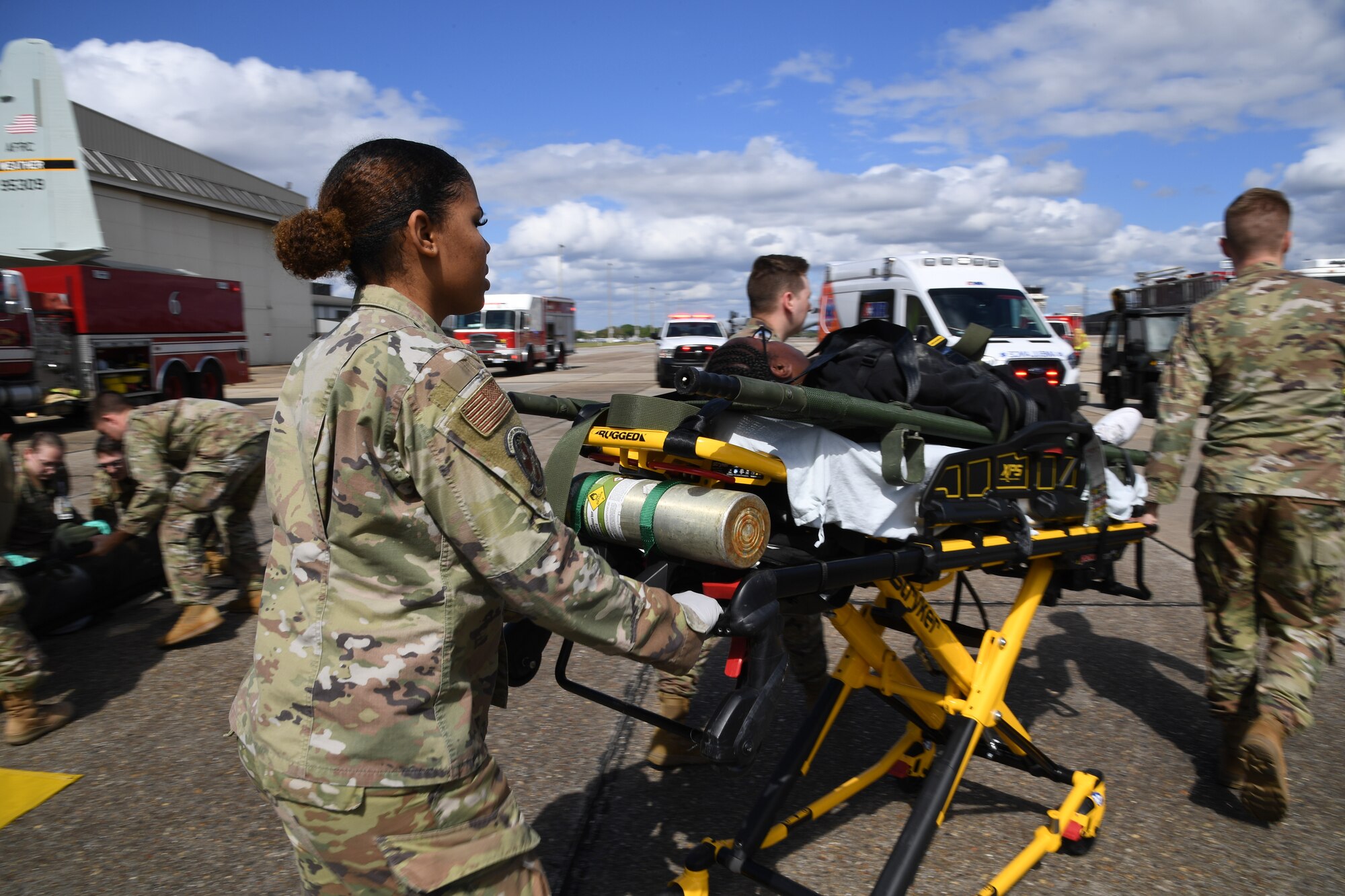 Members of the 81st Medical Group transport a simulated patient to an ambulance during the aircraft mishap exercise at Keesler Air Force Base, Mississippi, March 16, 2023.