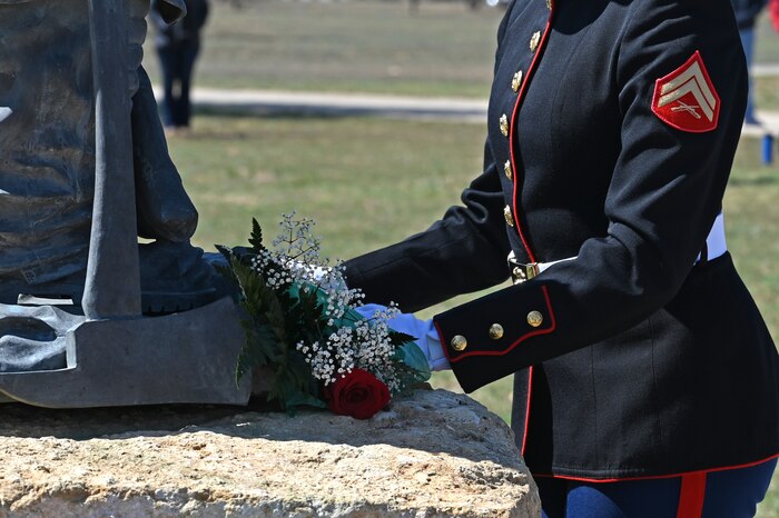 A member of the joint service color guard places a bouquet of flowers upon the fallen firefighter memorial statue during the annual Department of Defense Fallen Firefighter Memorial Service, Goodfellow Air Force Base, Texas, March 17, 2023. The memorial symbolizes the heroism and sacrifice of DOD firefighters that gave their lives in the line of duty. (U.S. Air Force photo by Senior Airman Ashley Thrash)