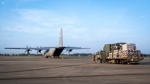 Senior Airman Shayne Paulk, left, a 921st Contingency Response Squadron aerial port mobility team member, waits to load a Lockheed C-130 Hercules aircraft during AGILE FLAG 23-1 at Savannah Air National Guard Base, Georgia, March 3, 2023.
