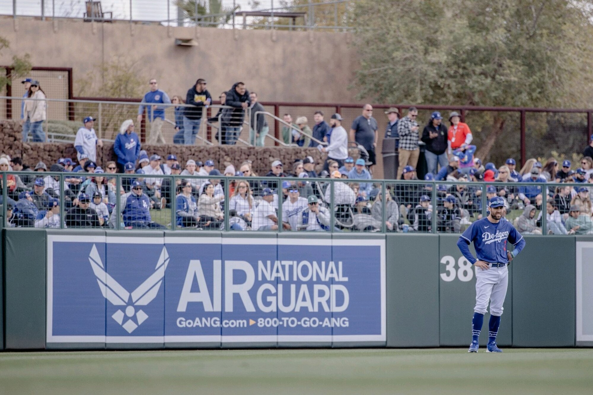 A Los Angeles Dodgers player stands in front of the Air National Guard outfield banner during a spring baseball game at Camelback Ranch–Glendale baseball complex in Phoenix, Feb. 28, 2023.