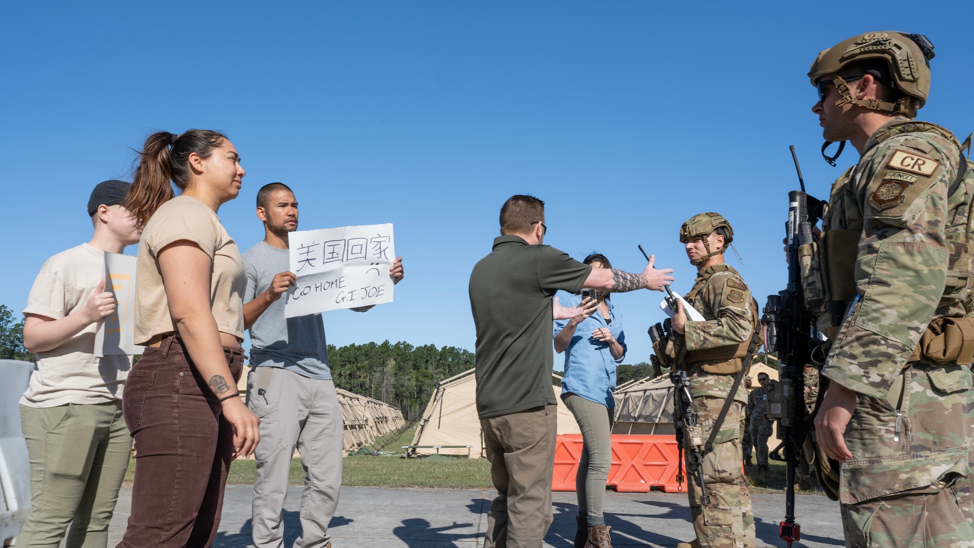 Senior Airman Kolby Karim, left, a 921st Contingency Response Squadron fire team member, and Tech. Sgt. John Powerll, 821st CRS security forces flight sergeant, talks down a simulated protest during AGILE FLAG 23-1 at Hunter Army Airfield, Georgia, March 5, 2023.