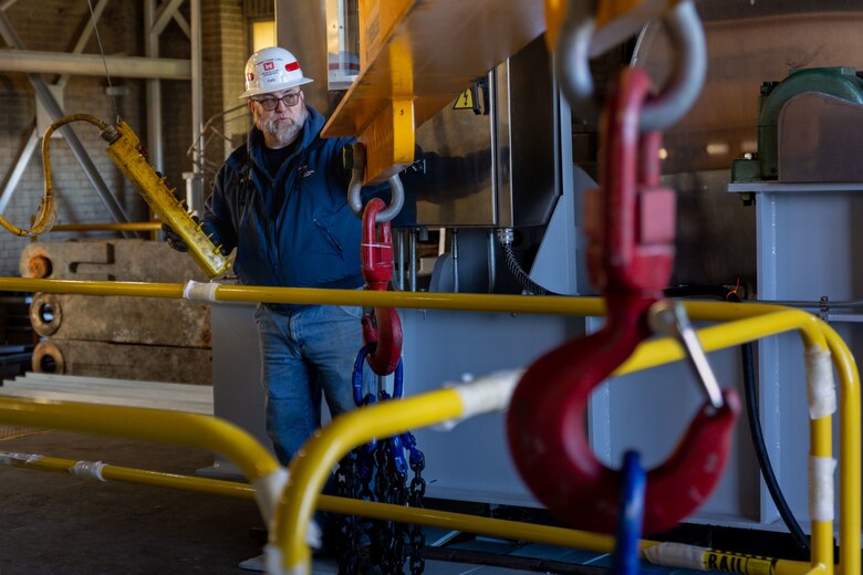 Brent Kelly, a maintenance mechanic, prepares a lifting beam to lift a new gate hoist during its installation in the control tower at the Crooked Creek Dam in Ford City, Pennsylvania, Feb. 14, 2023. BCI Construction installed four new hoists – each weighing 38,000 pounds apiece and control the dam’s gates – at Crooked Creek Lake to modernize the facility’s machinery and improve usage. The new hoists make the machinery safer and more efficient to use, with digital displays that are more accurate and easier to read. The original hoists were in operation since the dam was built in 1938. (U.S. Army Corps of Engineers photo by Andrew Byrne)