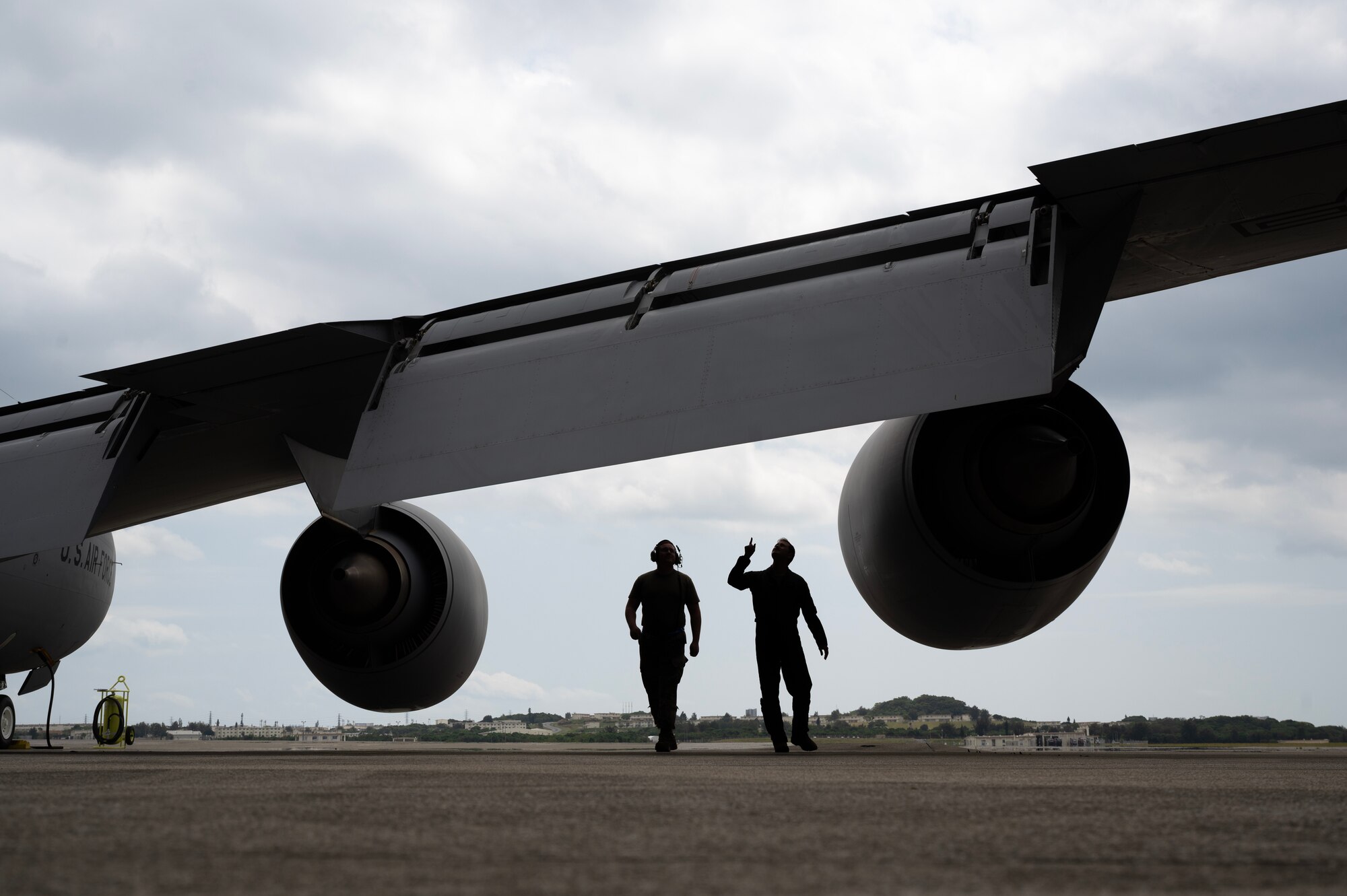 U.S. Air Force Capt. Steven Lau, a KC-135 Stratotanker pilot assigned to the 909th Air Refueling Squadron, and a crew chief assigned to the 718th Aircraft Maintenance Squadron, conduct pre-flight checks prior to a refueling mission at Kadena Air Base, Japan, March 19, 2023. The 909th ARS is the premiere force for aerial refueling operations in the Indo-Pacific theater, supporting U.S. forces and regional allies and partners. (U.S. Air Force photo by Senior Airman Jessi Roth)