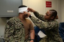 SAN DIEGO (March 8, 2023) – Hospital Corpsman 2nd Class Lacee Peel, assigned to USS Boxer (LHD 4) and a native of Atlanta, Georgia, applies an eye shield to Hospital Corpsman 2nd Class Gregzon Fontanilla, assigned to Fleet Surgical Team 9 and a native of Tamuning, Guam, during a mass casualty drill aboard Boxer. Boxer, Fleet Surgical Team Five and Navy Medicine Readiness and Training Command San Diego Sailors participated in a two-day mass casualty drill simulating Boxer as a casualty receiving treatment ship. Boxer is a Wasp-class amphibious assault ship homeported in San Diego. (U.S. Navy photo by Mass Communication Specialist 1st Class Kelsey J. Hockenberger)