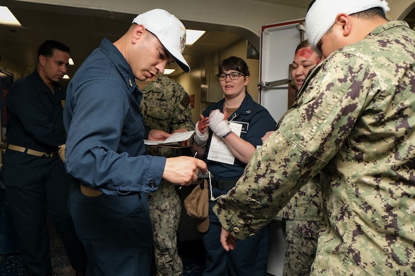 SAN DIEGO (March 8, 2023) – Chief Hospital Corpsman Daniel Jimenez, a native of Riverside, California, assesses the tactical combat casualty care card of a simulated casualty during a mass casualty drill aboard USS Boxer (LHD 4). Boxer, Fleet Surgical Team Five and Navy Medicine Readiness and Training Command San Diego Sailors participated in a two-day mass casualty drill simulating Boxer as a casualty receiving treatment ship. Boxer is a Wasp-class amphibious assault ship homeported in San Diego. (U.S. Navy photo by Mass Communication Specialist 1st Class Kelsey J. Hockenberger)