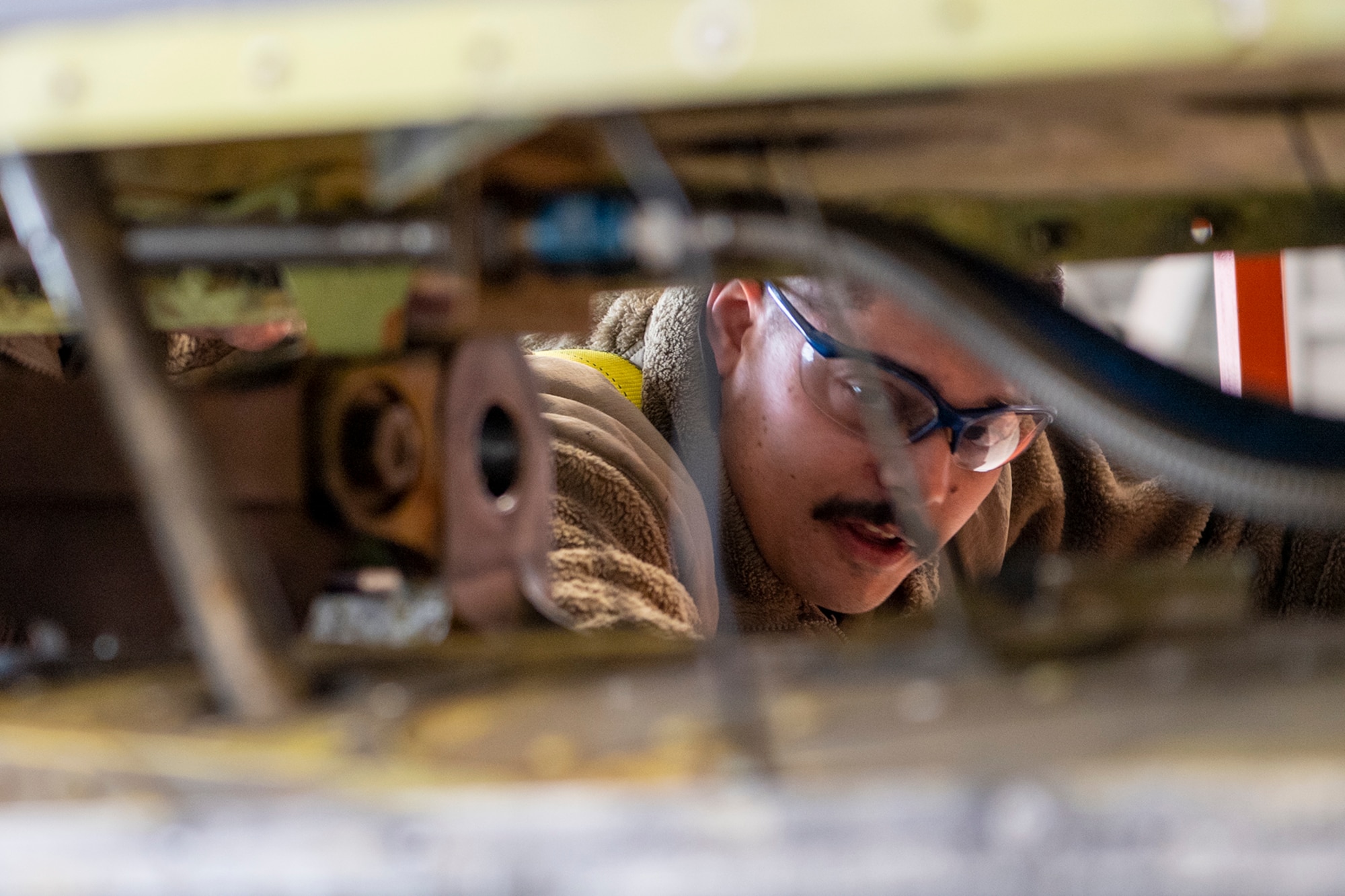 Tech. Sgt. Joel Pfeiffer, 434th Maintenance Squadron repair and reclamation technician, peers into the confined workspace where faulty tail pins had to be replaced on March 16, 2023. The pin replacement was mandated by a time compliant technical order issued recently that grounded KC-135R Stratotankers that didn’t meet required specifications. (U.S. Air Force photo by Douglas Hays)