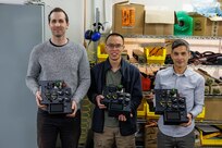 Engineers in Naval Surface Warfare Center, Carderock Division’s Expeditionary and Development Power and Energy Branch from left: Matthew Huffman, technical area lead, Kevin Lin, electrical engineer and James Mulford, mechanical engineer, display their invention, the Lithium 6T Top Cap, in West Bethesda, Md., on March 8. The engineers are shown with three of their four prototypes, which is a modular, field-reconfigurable direct current power distribution device that can be installed and mounted on top of a Li6T battery. (U.S. Navy photo by Aaron Thomas)