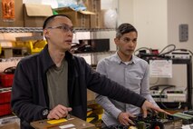 Electrical engineer Kevin Lin (left) and mechanical engineer James Mulford (right) explain their new invention, the Lithium 6T Top Cap, during an interview in West Bethesda, Md., on March 8. (U.S. Navy photo by Aaron Thomas)
