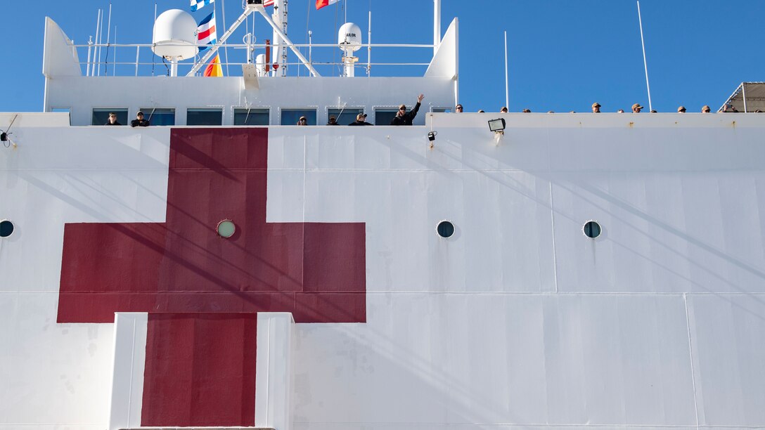 Sailors assigned to the hospital USNS Comfort (T-AH 20) wave to friends and family as Comfort arrives in Norfolk, Virginia, Dec. 21, 2022. Comfort returns after a deployment to U.S. 4th Fleet in support of Continuing Promise 2022, a humanitarian assistance and goodwill mission conducting direct medical care, expeditionary veterinary care, and subject matter expert exchanges with five partner nations in the Caribbean, Central and South America.