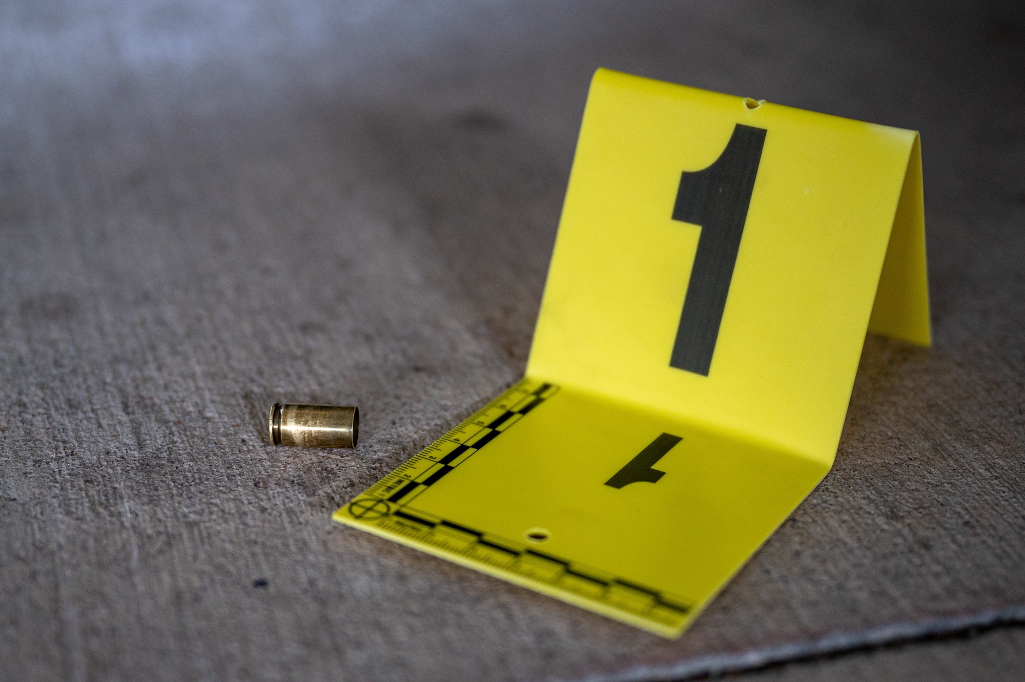 A 9mm bullet casing sits on the floor as a prop simulated crime scene March 9, 2023, at McConnell Air Force Base, Kansas. The Air Force Office of Special Investigations handles serious offenses including espionage, terrorism, drug use, and other illegal activities that undermine the mission of the Department of Defense. (U.S. Air Force photo by Senior Airman Zachary Willis)