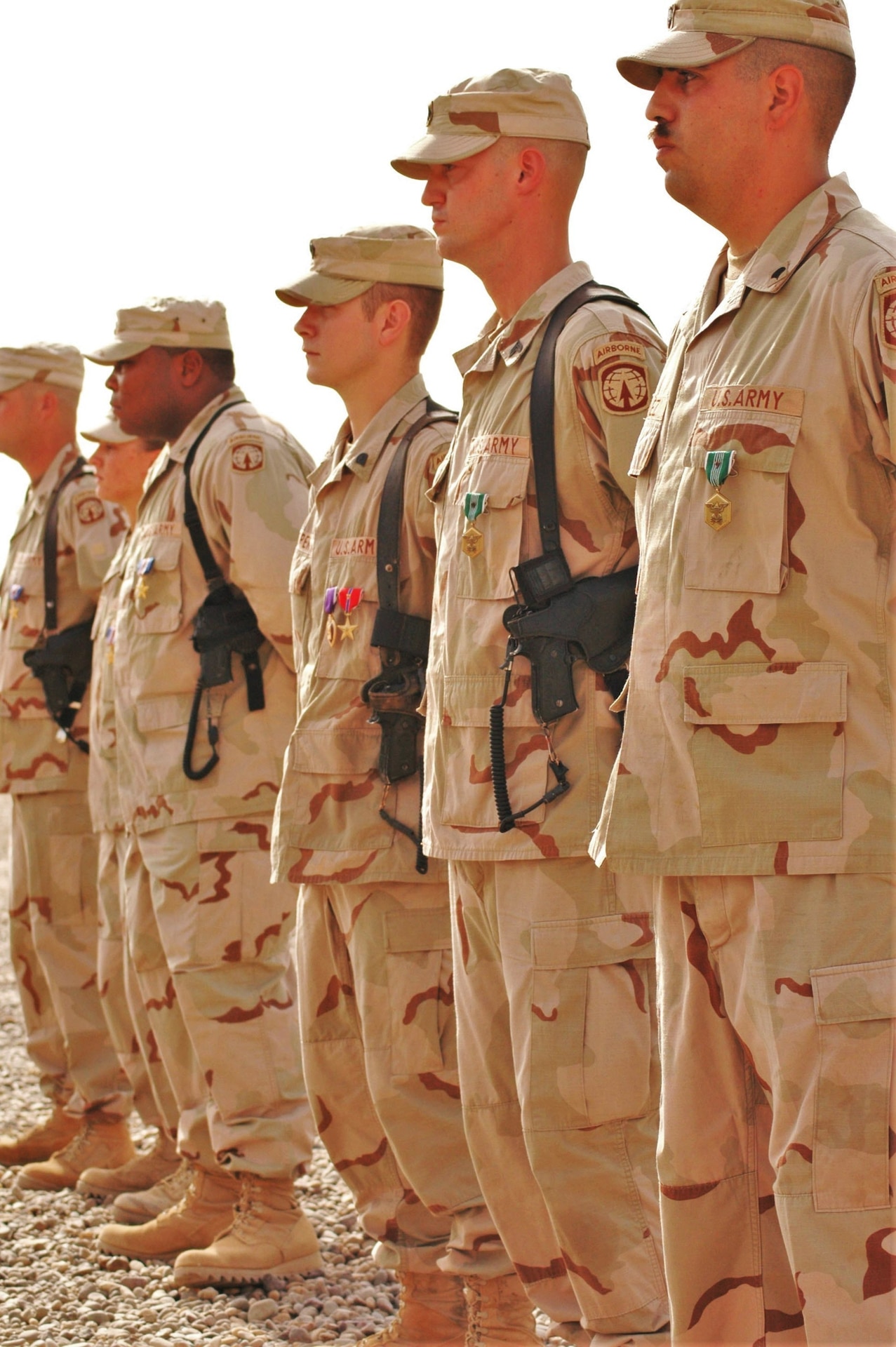 Soldiers from the 617th Military Police Company, Richmond, Ky., stand at the position of attention during an awards ceremony held in their honor at Camp Liberty, Iraq, June, 16, 2005. Receiving the Silver Star were: Staff Sgt. Timothy F. Nein from Henryville, Ind.; Sgt. Leigh Ann Hester from Bowling Green, Ky., and Spc. Jason Mike from Radcliff, Ky. Receiving the Bronze Star with V device were: Spc. Ashley Pullen from Danville, Ky.; Spc. William Haynes II (who was unable to make the ceremony); and Spc. Casey Cooper from Princeton, Ky. Cooper was also awarded the Purple Heart for injuries sustained during the attack. Receiving the Army Commendation Medal with V device were: Sgt. Dustin Morris from Murray, Ky., and Spc. Jesse Ordunez from Marshall County, Ky. (U.S. Army photo by Spc. Jeremy D. Crisp.)