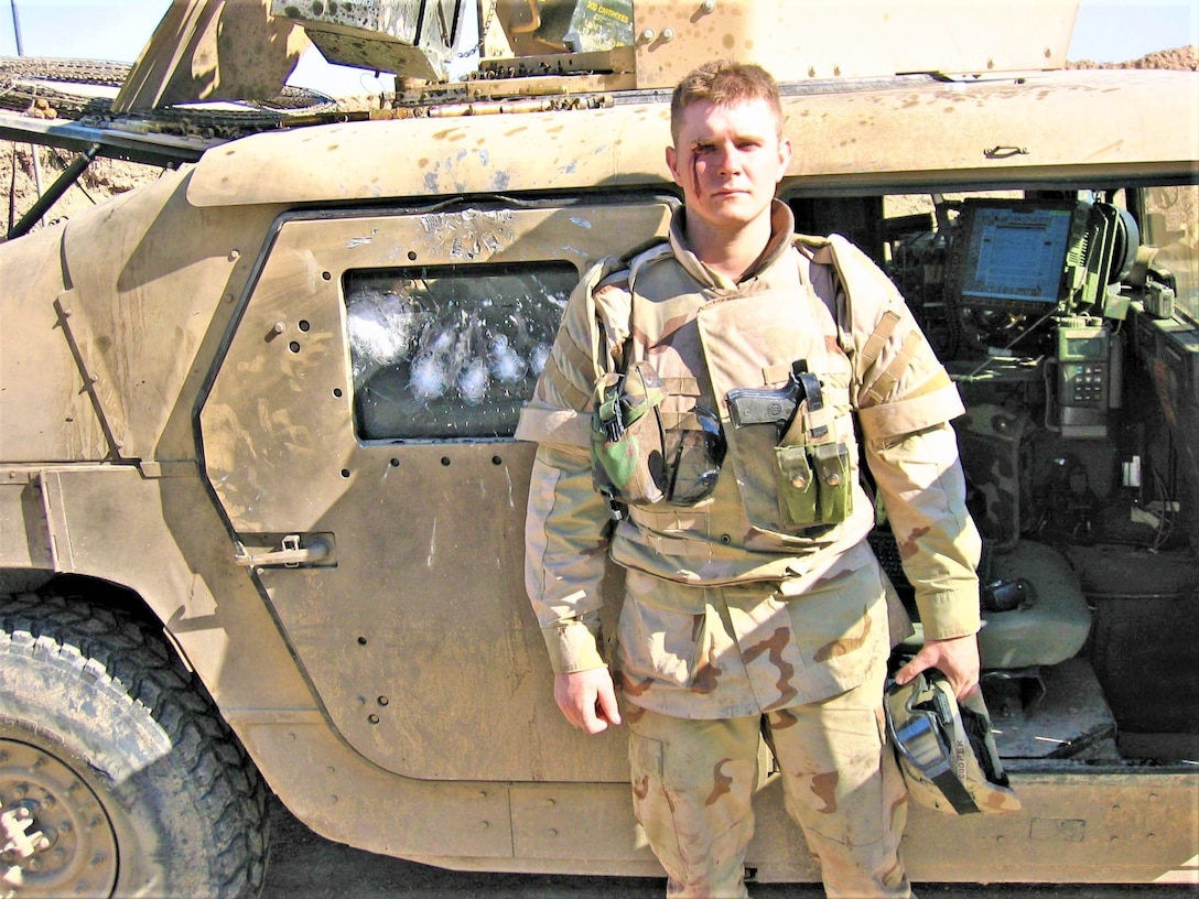 Spc. Casey Cooper, gunner, 4th Platoon, 617th Military Police Company, 503rd MP Battalion., 18th MP Brigade, was knocked unconscious and received a minor wound when his vehicle received a direct hit from a rocket-propelled grenade above the right-side passenger window (seen just above his right shoulder). Cooper was revived and helped his fellow soldiers defeat an insurgent attack on a coalition supply convoy March 20, 2005, about 18 miles southeast of Baghdad. (U.S. Army photo by Sgt. 1st Class Marshall P. Ware)