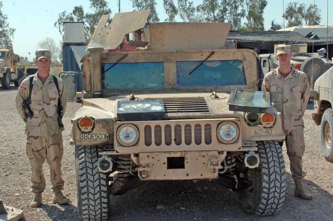Staff Sgt. Timothy F. Nein, squad leader, 617th Military Police Company, 503rd MP Battalion, Fort Bragg, N.C., (left,) and Sgt. Dustin T. Morris, team leader, 617th, stand beside their recently repaired Humvee that sustained multiple impacts from rounds fired by insurgents during an ambush March 20 on a supply route southeast of Baghdad.  The Humvee armor repelled the rounds, and the Soldiers from the 617th thwarted the attack, sustaining only three injuries during the 45-minute firefight.  (U.S. Army photo by Spc. Jeremy D. Crisp)