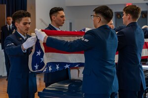 Honor graduates fold flag.