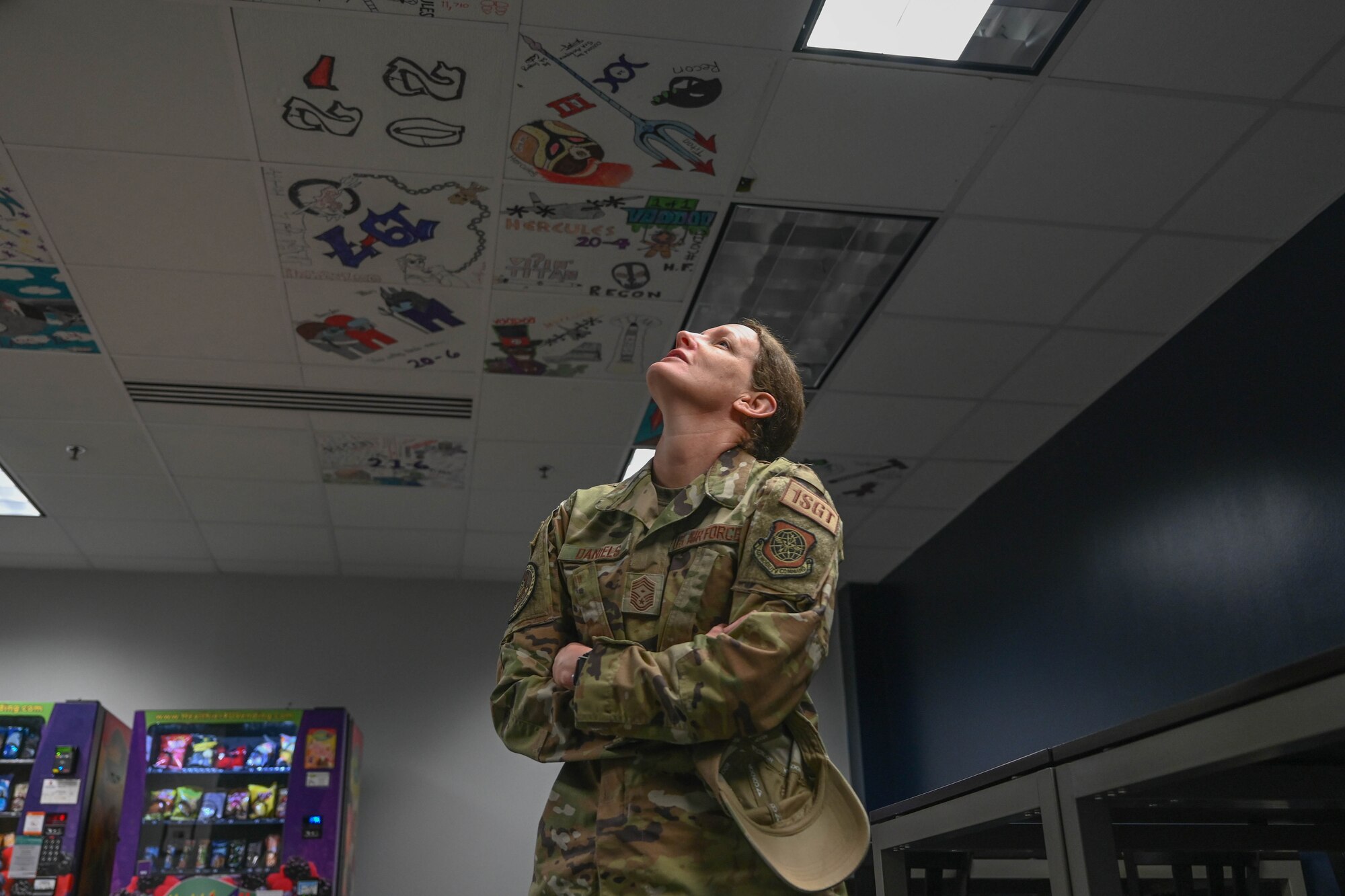 A woman in uniform looks at the ceiling.