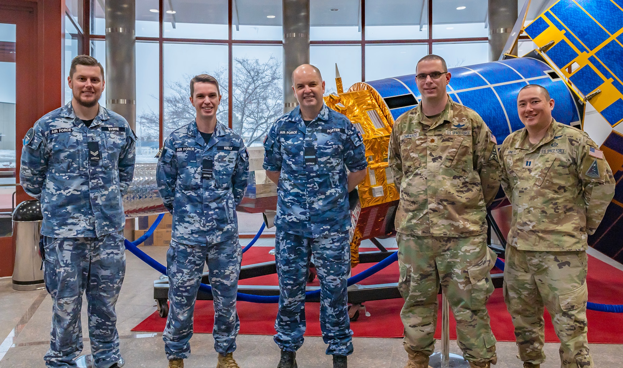 Three Australian Air Force members and two United States Space Force members pose for a photo.