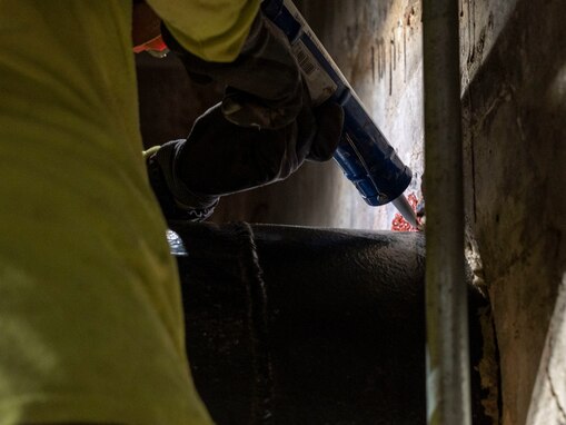 A contractor applies fire-resistant caulking during a repair at Red Hill Bulk Fuel Storage Facility (RHBFSF), Halawa, Hawaii, March 10, 2023. Joint Task Force-Red Hill is in phase three of its five-phase defueling plan, as contractors and Navy technical experts complete repairs to ensure a safe and expeditious defueling of the RHBFSF. (U.S. Navy photo by Petty Officer 3rd Class James Finney)