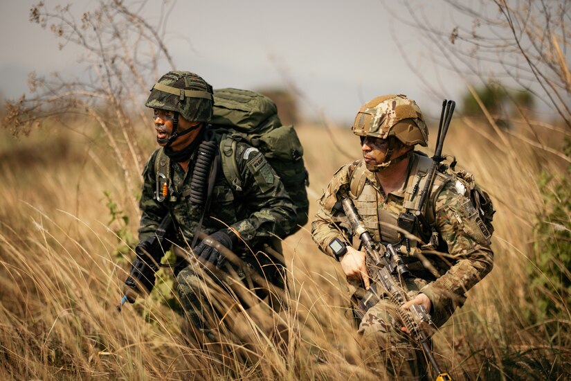 U.S. Army Paratroopers with the 82nd Airborne Division and Royal Thai Army Soldiers kneel side-by-side after executing a Strategic Airborne Operation during Exercise Cobra Gold 2023, near Thanarat Drop Zone, Kingdom of Thailand, March 2, 2023.