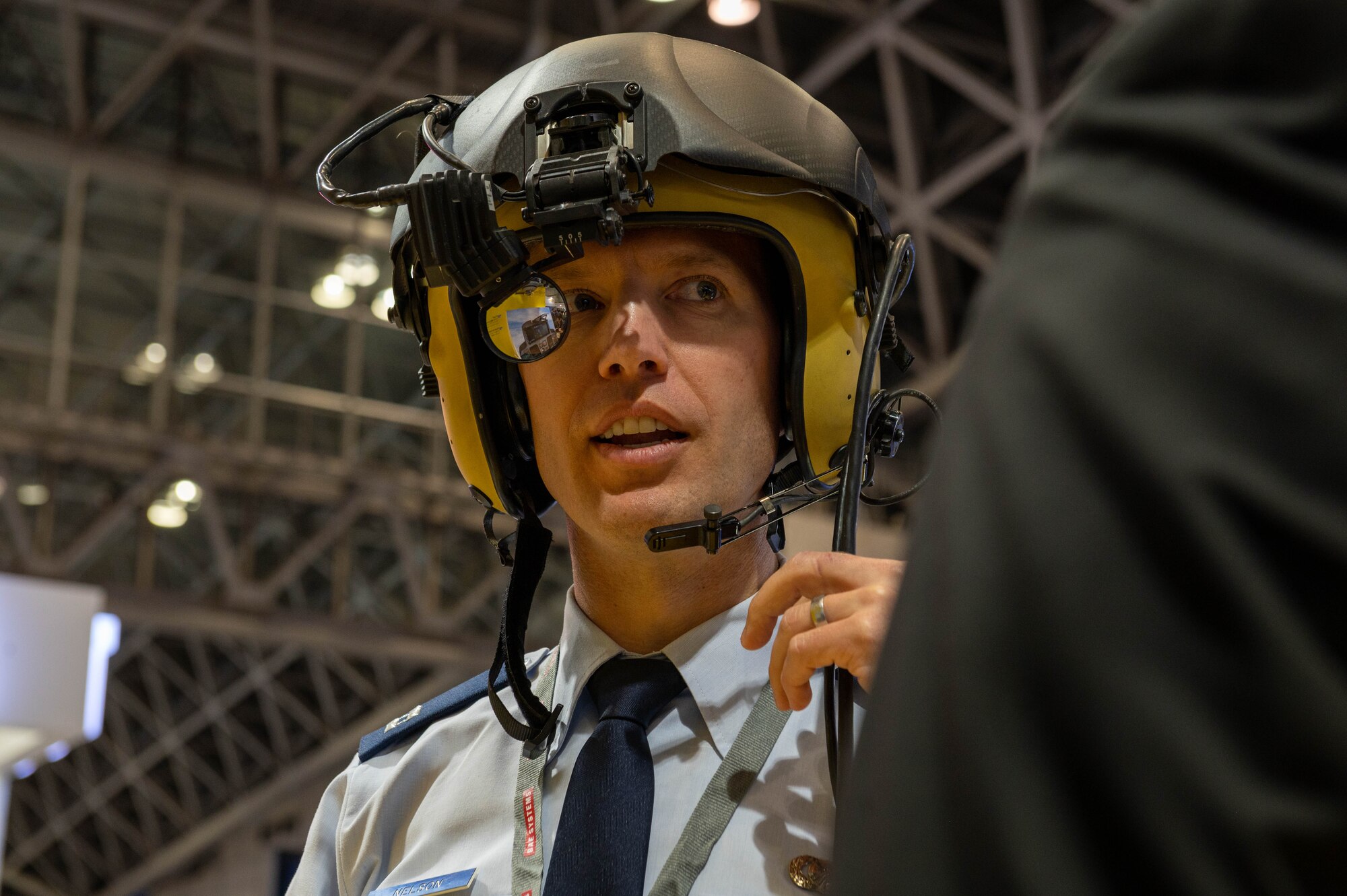 A white man wears a yellow helmet-mounted display.