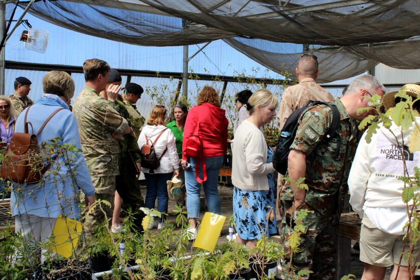 Lena Schnell (center, in neon green), contractor with the Center for Environment Management of Military Lands at U.S. Army Garrison  Pōhakuloa Training Area briefing foreign military attachés and their spouses on the garrison’s natural resources program to protect and manage endangered and threatened, and native plants, March 9, 2023.