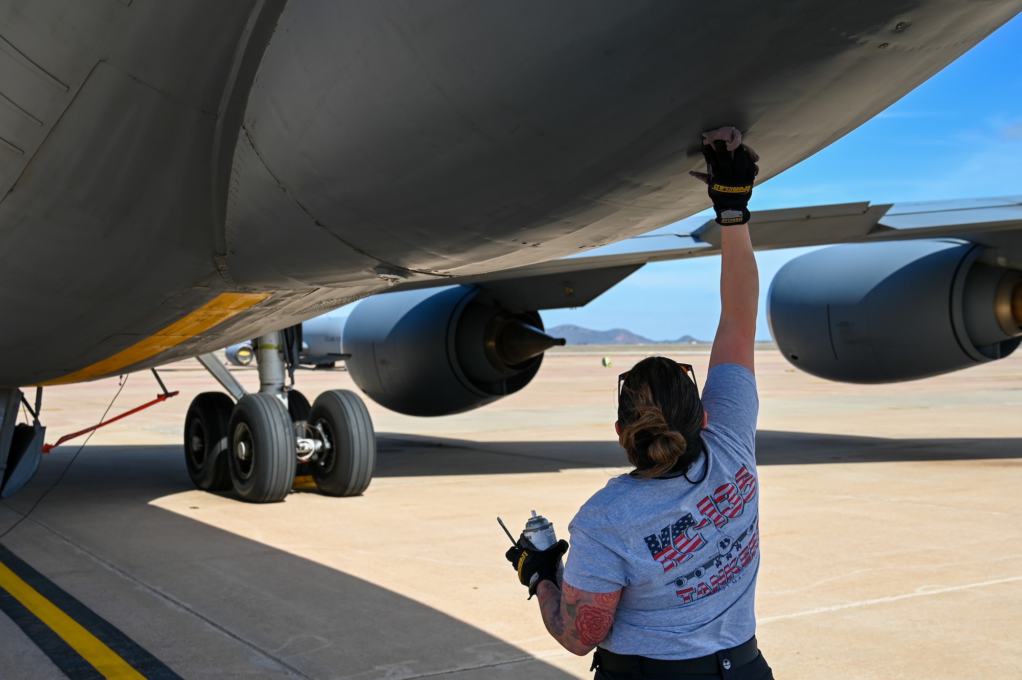 Julianne Martinez, 97th Maintenance Group KC-135 Stratotanker crew chief, wipes an oil-like spray on a KC-135 at Altus Air Force Base, Oklahoma, March 15, 2023. Martinez is one of two female KC-135 crew chiefs at the wing. (U.S. Air Force photo by Senior Airman Kayla Christenson)