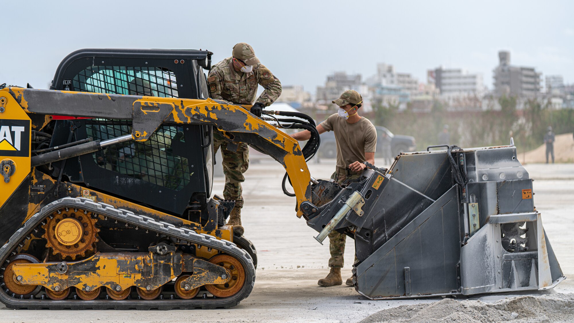 Airmen operate a compact track loader.