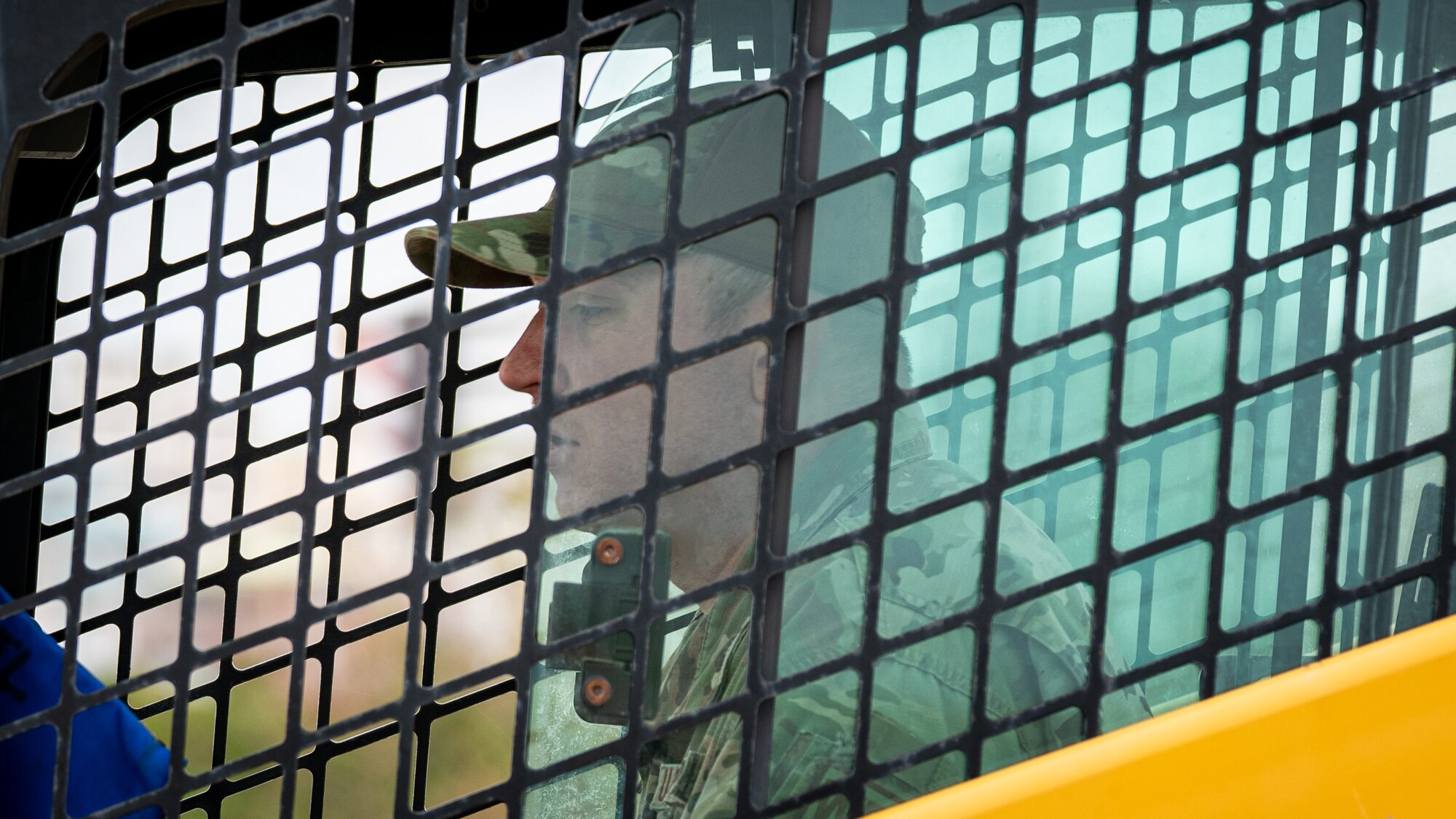 An Airman operates a compact track loader.